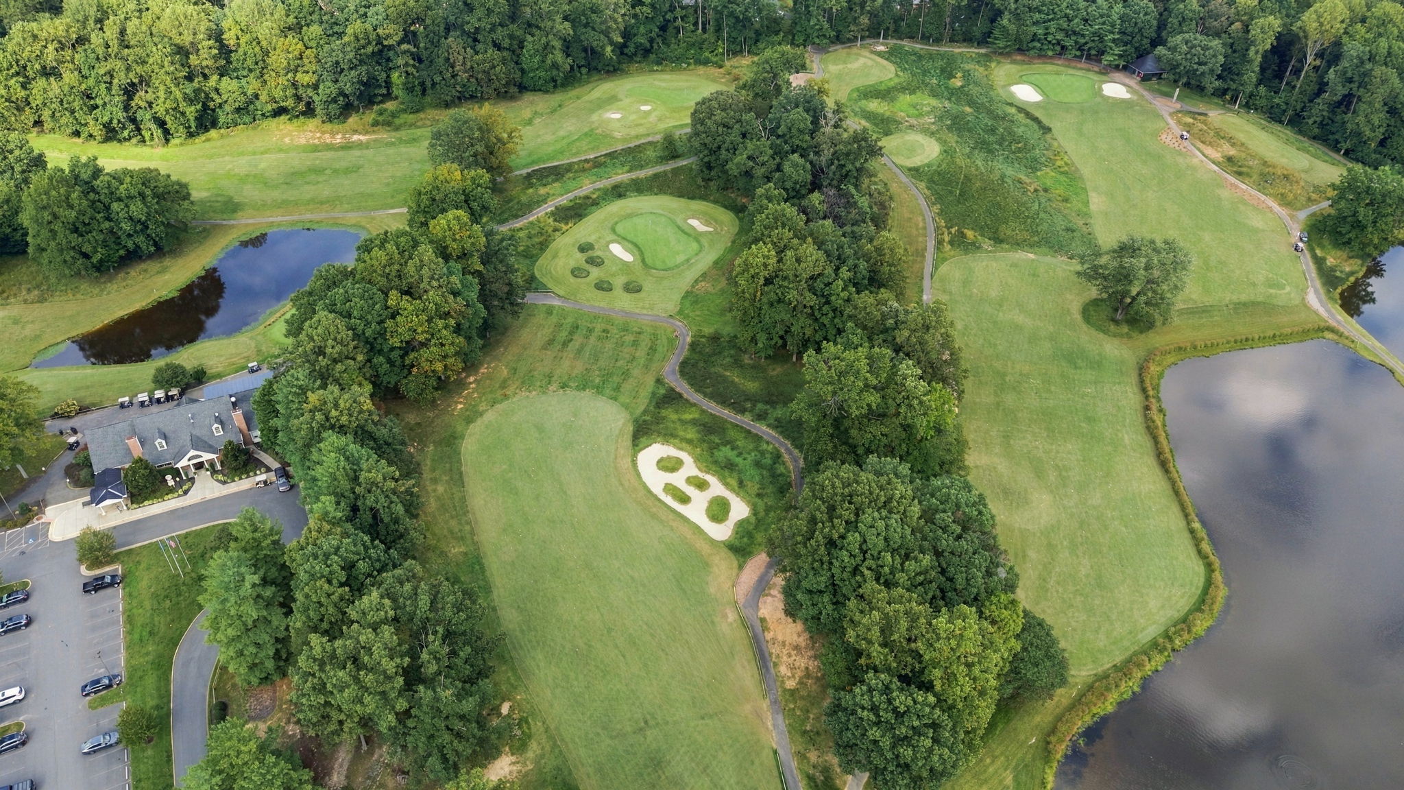 Aerial view of greens, bunkers, ponds and wooded fairways at Penderbrook Golf Club in Fairfax, Virginia